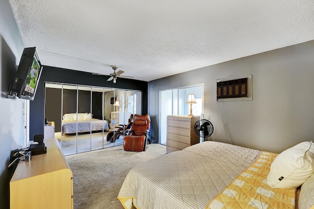 carpeted bedroom with a closet, ceiling fan, and a textured ceiling