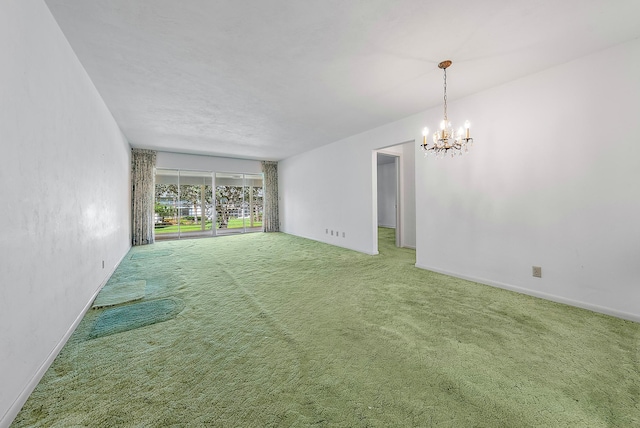 carpeted empty room featuring a notable chandelier