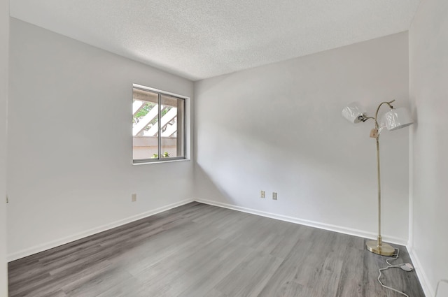 spare room with a textured ceiling and hardwood / wood-style floors