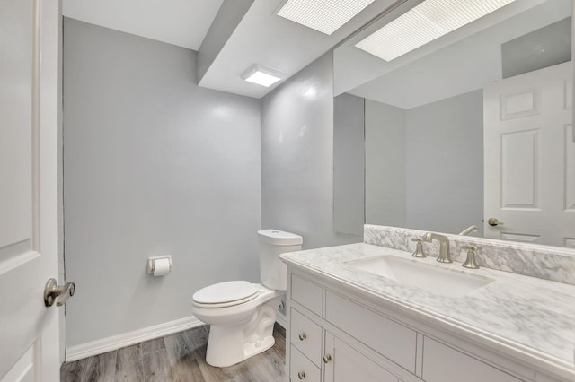 bathroom featuring vanity, toilet, and hardwood / wood-style flooring