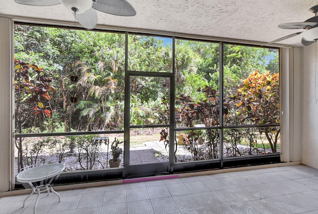 unfurnished sunroom featuring ceiling fan