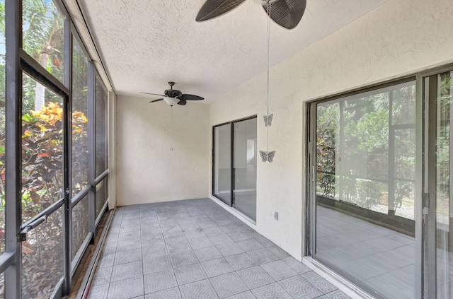 unfurnished sunroom featuring ceiling fan