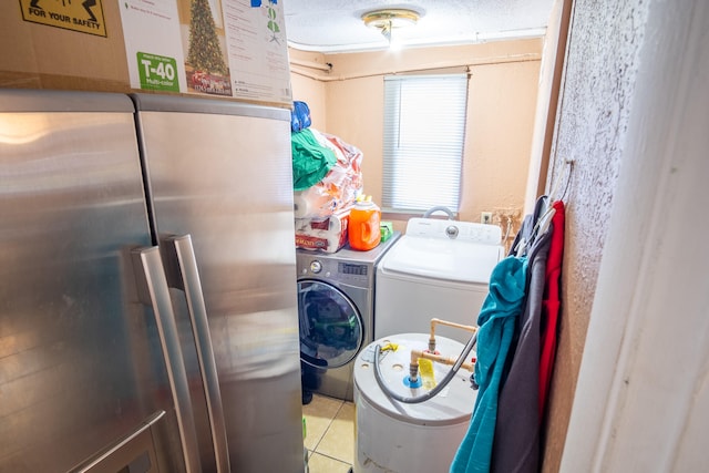 laundry room featuring a textured ceiling, washer and clothes dryer, and light tile patterned floors