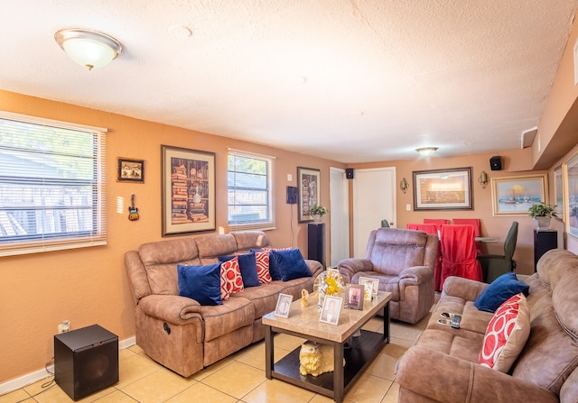 living room with a textured ceiling, light tile patterned floors, and a healthy amount of sunlight