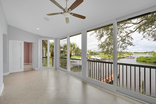 unfurnished sunroom with ceiling fan, lofted ceiling, and a water view