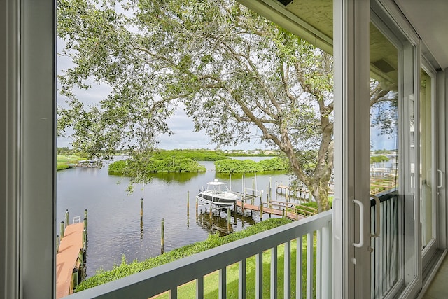 balcony with a water view and a dock