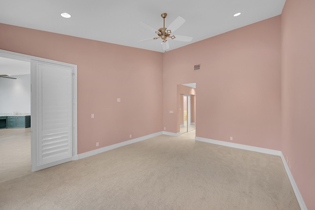 spare room featuring ceiling fan and light colored carpet