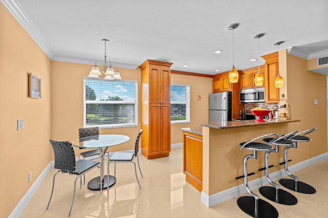 kitchen featuring kitchen peninsula, appliances with stainless steel finishes, decorative light fixtures, and tasteful backsplash