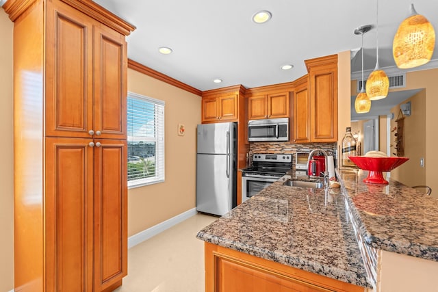 kitchen featuring sink, ornamental molding, kitchen peninsula, decorative light fixtures, and appliances with stainless steel finishes