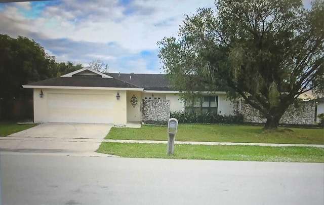 ranch-style house featuring a front lawn and a garage