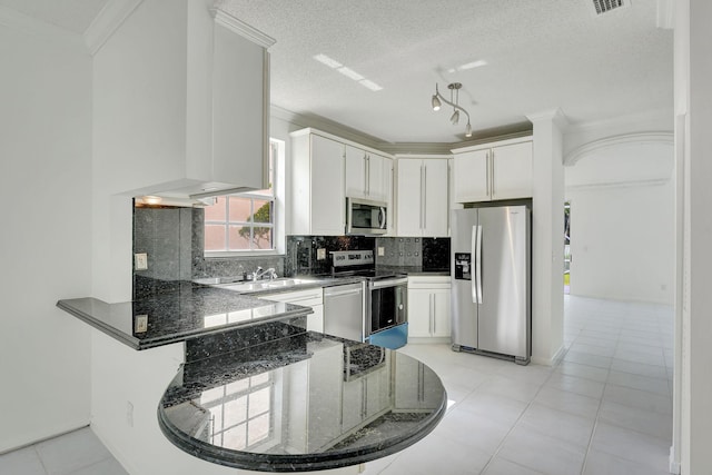 kitchen featuring kitchen peninsula, a textured ceiling, stainless steel appliances, white cabinets, and light tile patterned flooring