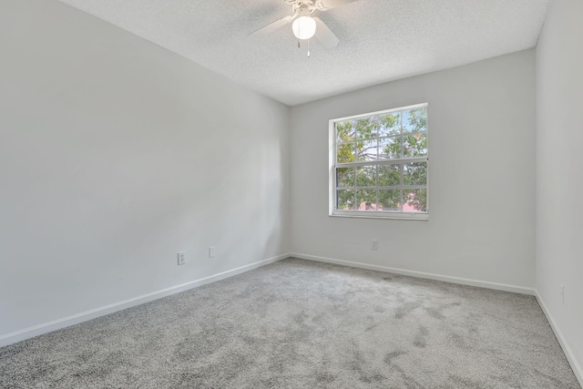 carpeted empty room with ceiling fan and a textured ceiling