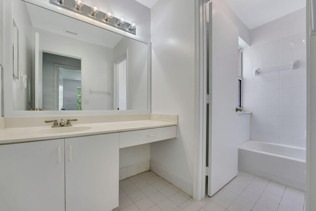 bathroom featuring tile patterned floors, vanity, and tiled shower / bath combo