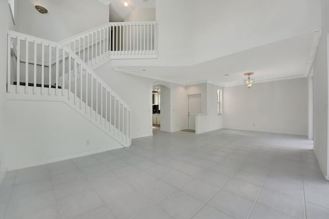 unfurnished living room featuring light tile patterned floors and a high ceiling