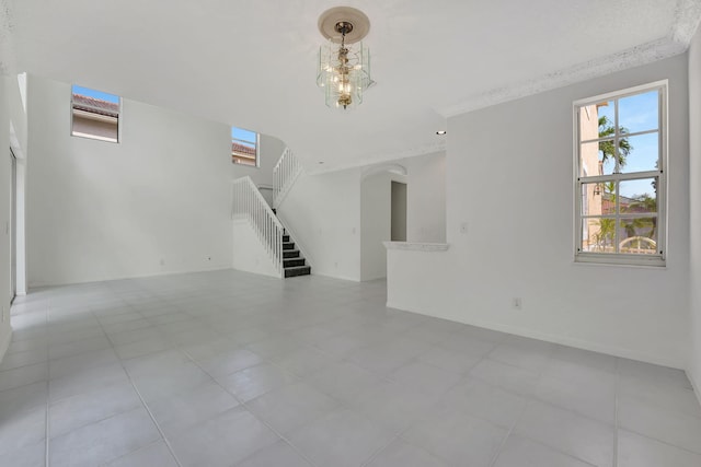 unfurnished living room featuring light tile patterned floors and a chandelier