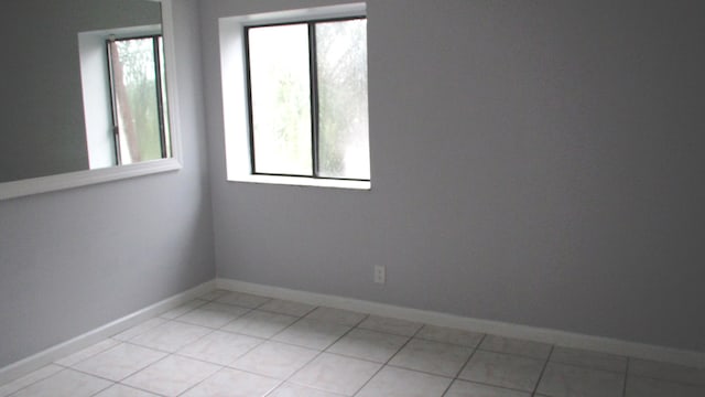 tiled spare room featuring a healthy amount of sunlight