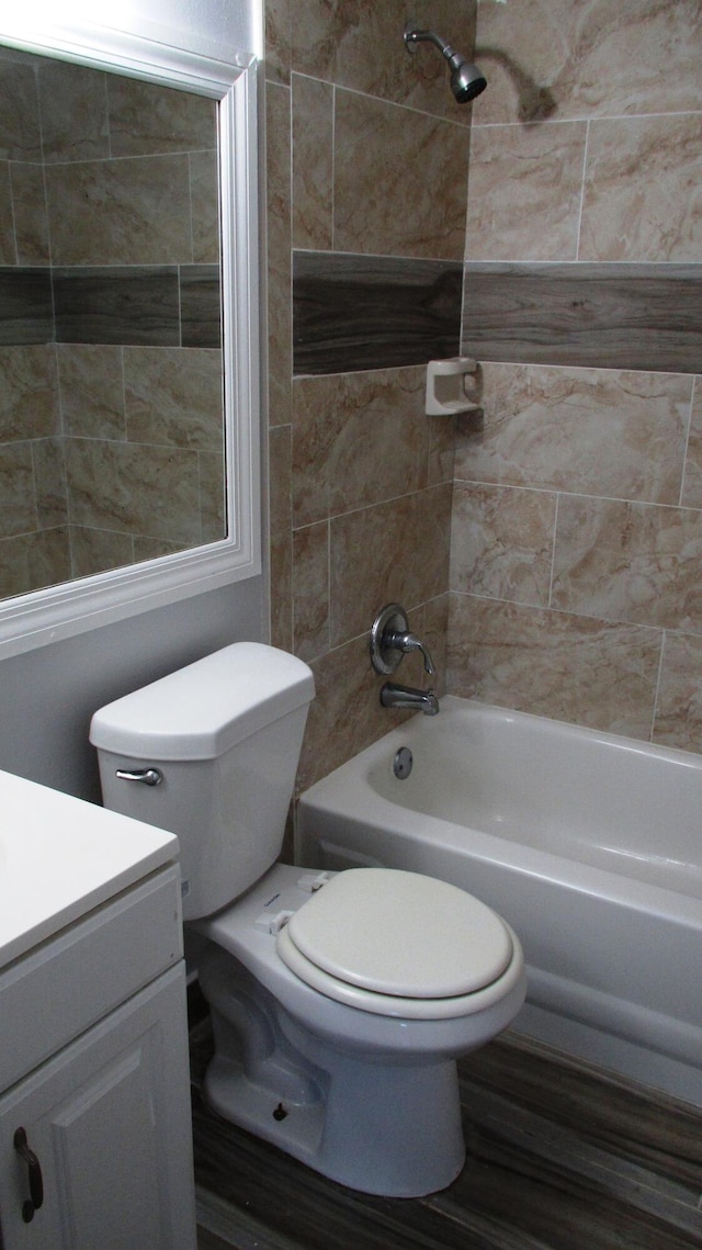 full bathroom featuring hardwood / wood-style floors, vanity, toilet, and tiled shower / bath