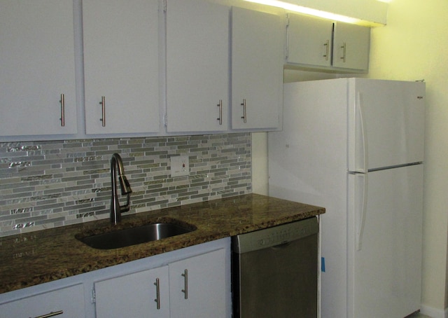 kitchen with dishwasher, dark stone counters, sink, and white cabinetry