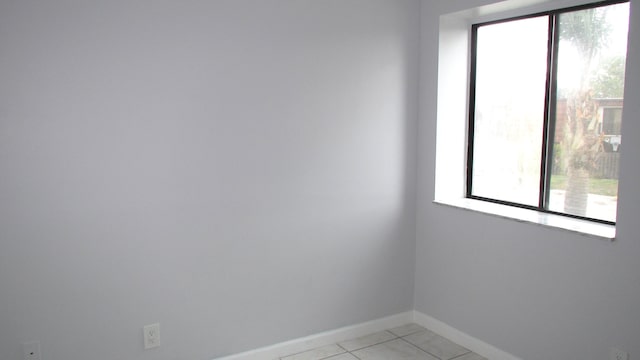 unfurnished room with light tile patterned flooring and baseboards