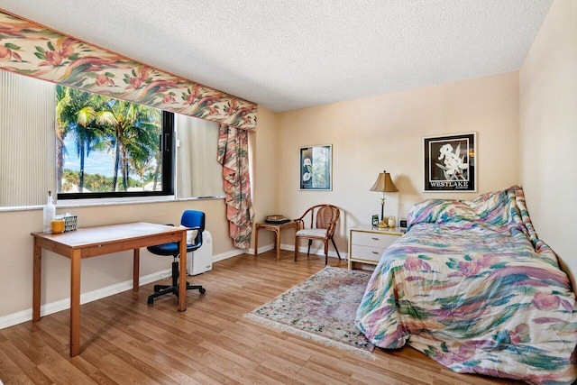 bedroom with a textured ceiling and light hardwood / wood-style flooring