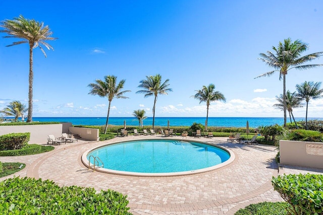 view of swimming pool featuring a patio area and a water view