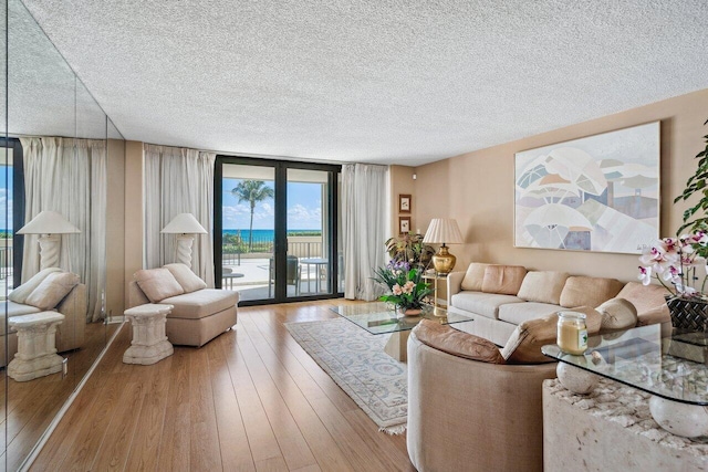 living room featuring floor to ceiling windows, hardwood / wood-style floors, and a textured ceiling