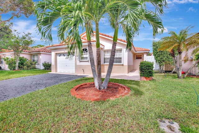 mediterranean / spanish-style home with a front yard and a garage