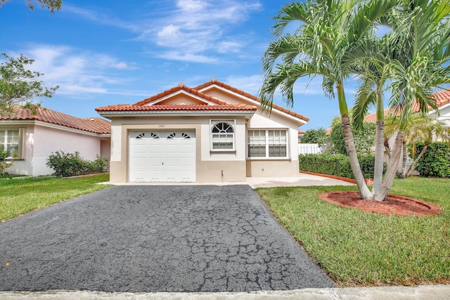 mediterranean / spanish-style house featuring a front yard and a garage