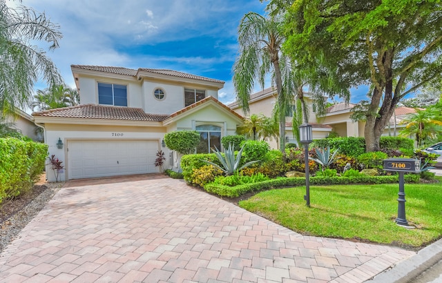 mediterranean / spanish home with a front lawn and a garage