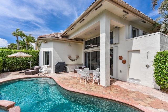 rear view of property featuring ceiling fan and a patio