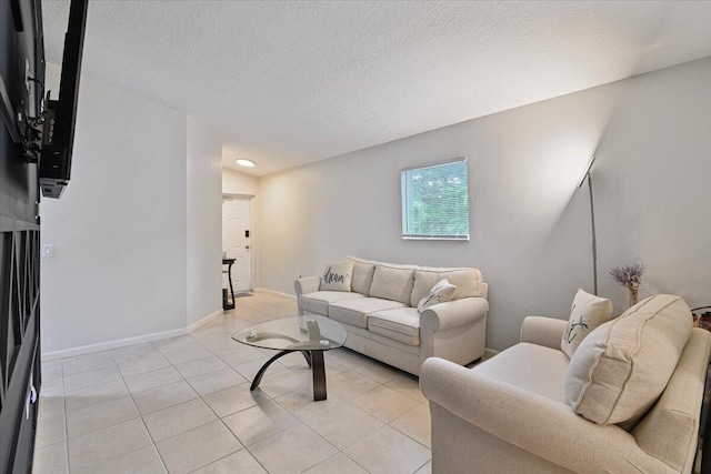 tiled living room featuring a textured ceiling