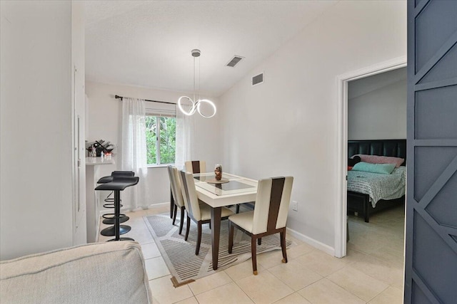 dining area featuring lofted ceiling and light tile patterned floors