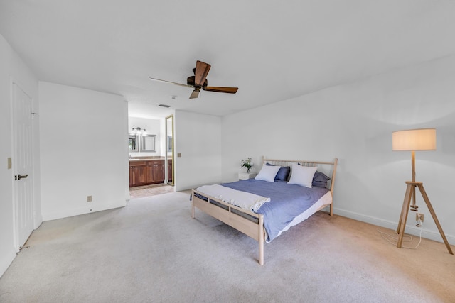 bedroom with light carpet, connected bathroom, and ceiling fan