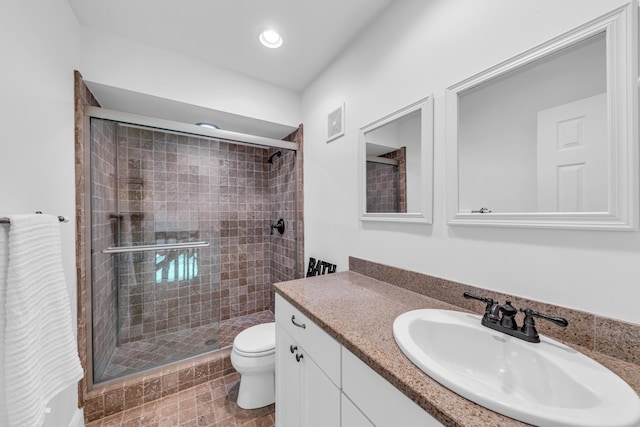 bathroom with vanity, toilet, and a shower with shower door