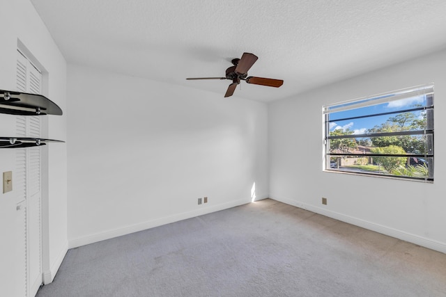 interior space with ceiling fan, light colored carpet, and a textured ceiling