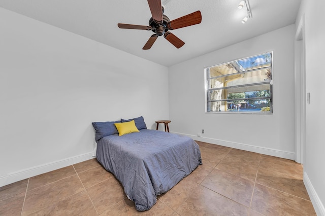 bedroom with ceiling fan and tile patterned floors