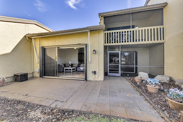 rear view of house featuring a patio and a balcony