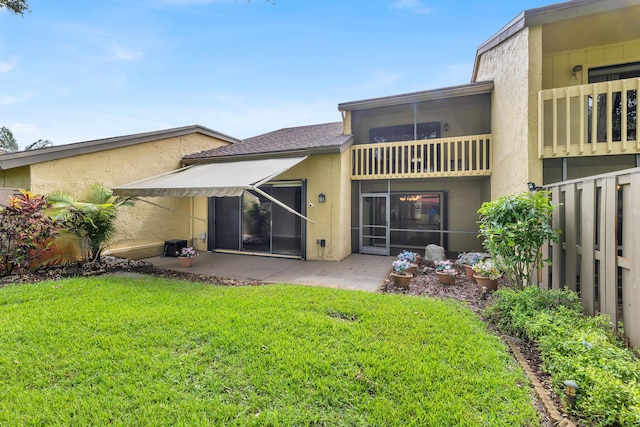 rear view of house featuring a lawn and a patio area