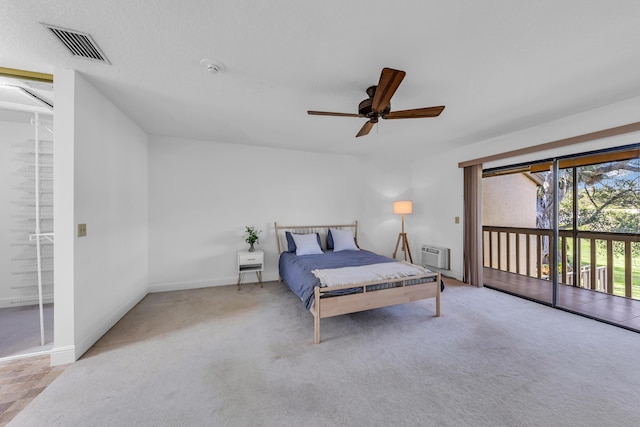 carpeted bedroom with ceiling fan, a wall mounted AC, and access to outside