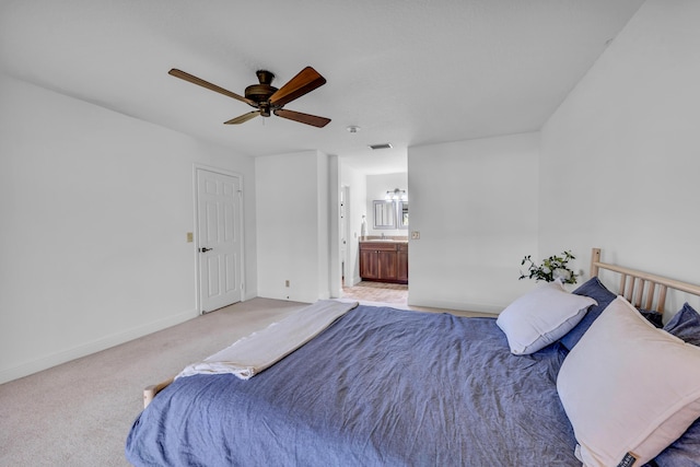 bedroom featuring light carpet, connected bathroom, and ceiling fan