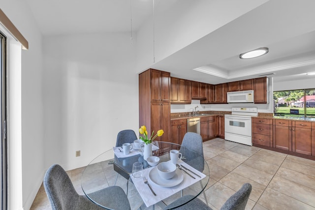 kitchen featuring white appliances, a raised ceiling, and light tile patterned floors