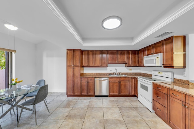 kitchen featuring light tile patterned flooring, sink, light stone counters, a tray ceiling, and white appliances