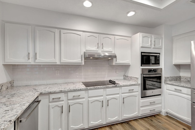 kitchen with extractor fan, white cabinetry, tasteful backsplash, light wood-type flooring, and stainless steel appliances