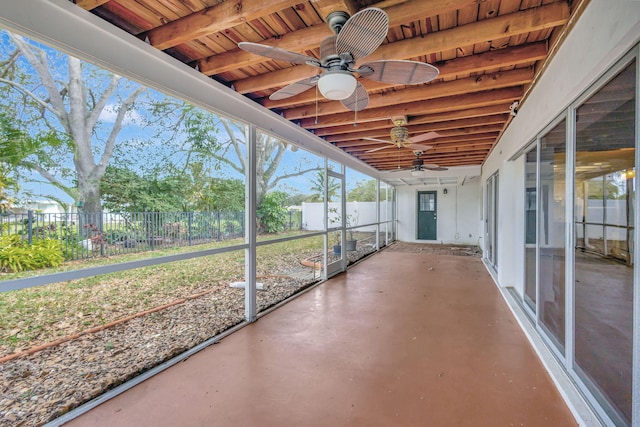 unfurnished sunroom featuring ceiling fan