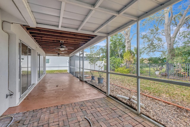 unfurnished sunroom featuring ceiling fan