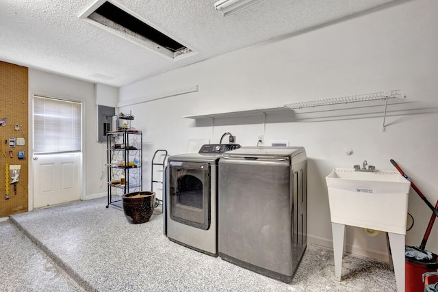 washroom featuring washing machine and dryer, sink, and a textured ceiling