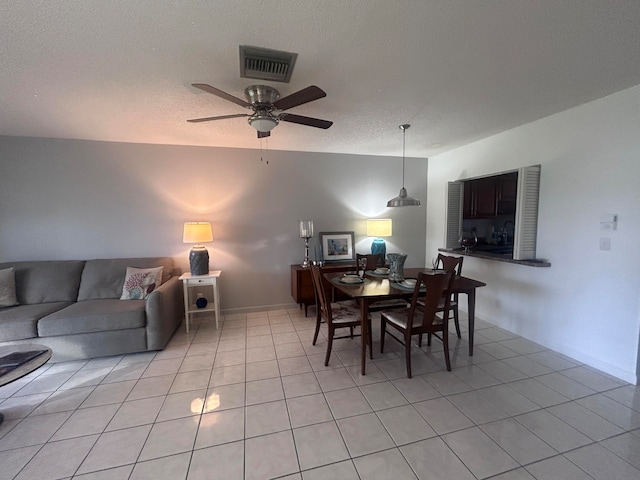 dining space featuring ceiling fan, light tile patterned floors, and a textured ceiling