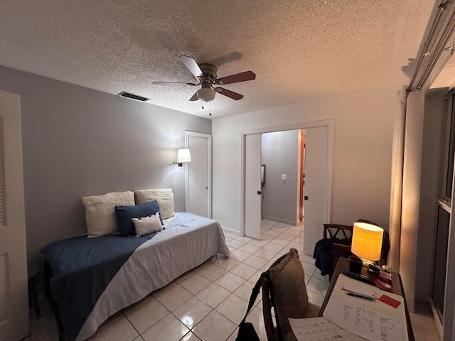 tiled bedroom featuring a textured ceiling and ceiling fan