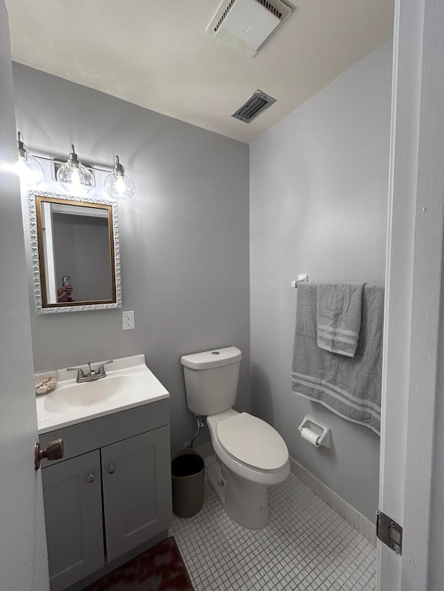 bathroom featuring tile patterned flooring, vanity, and toilet