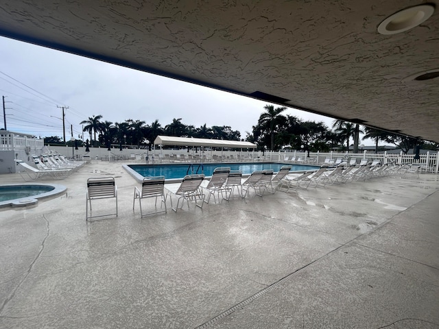 view of pool featuring a community hot tub and a patio